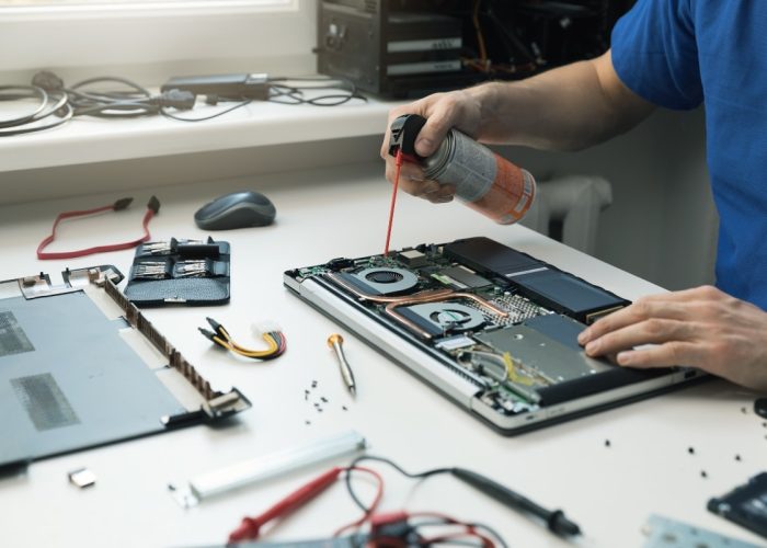 computer maintenance - technician blow out dust from laptop fan